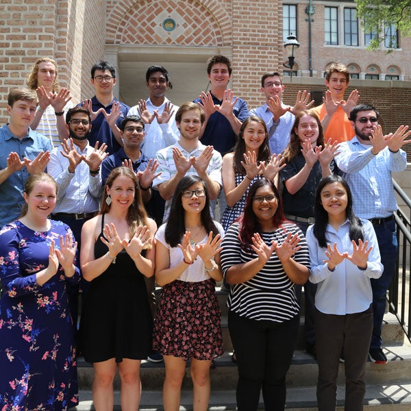 Rice students holding up owl hands