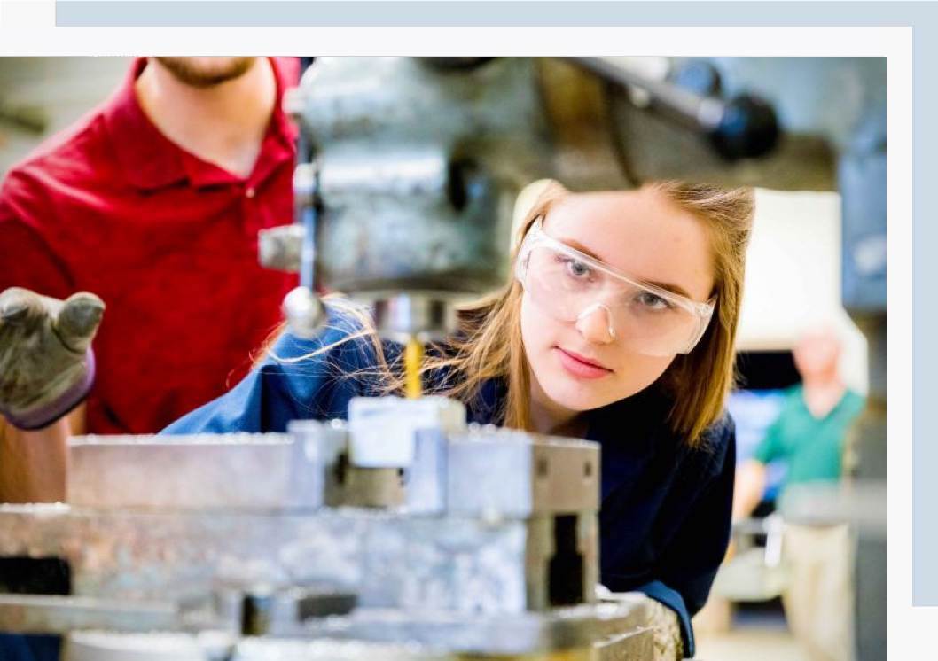 MEML engineering classes are hands-on. A woman wearing goggles working on a engineering project for her MEML class.