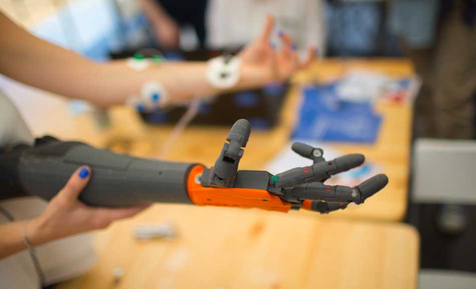 Engineers working on medical device product innovation in the form of a prosthetic arm and robotics