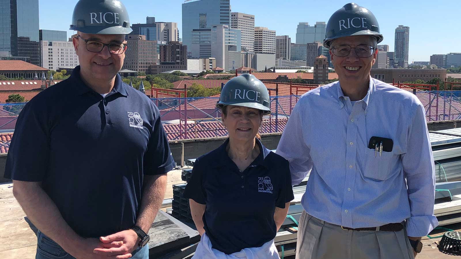 Dean Luay Nakhleh, left, Wanda Gass and Richard Gass wearing hard hats and standing atop the Ralph S. O'Connor Building.