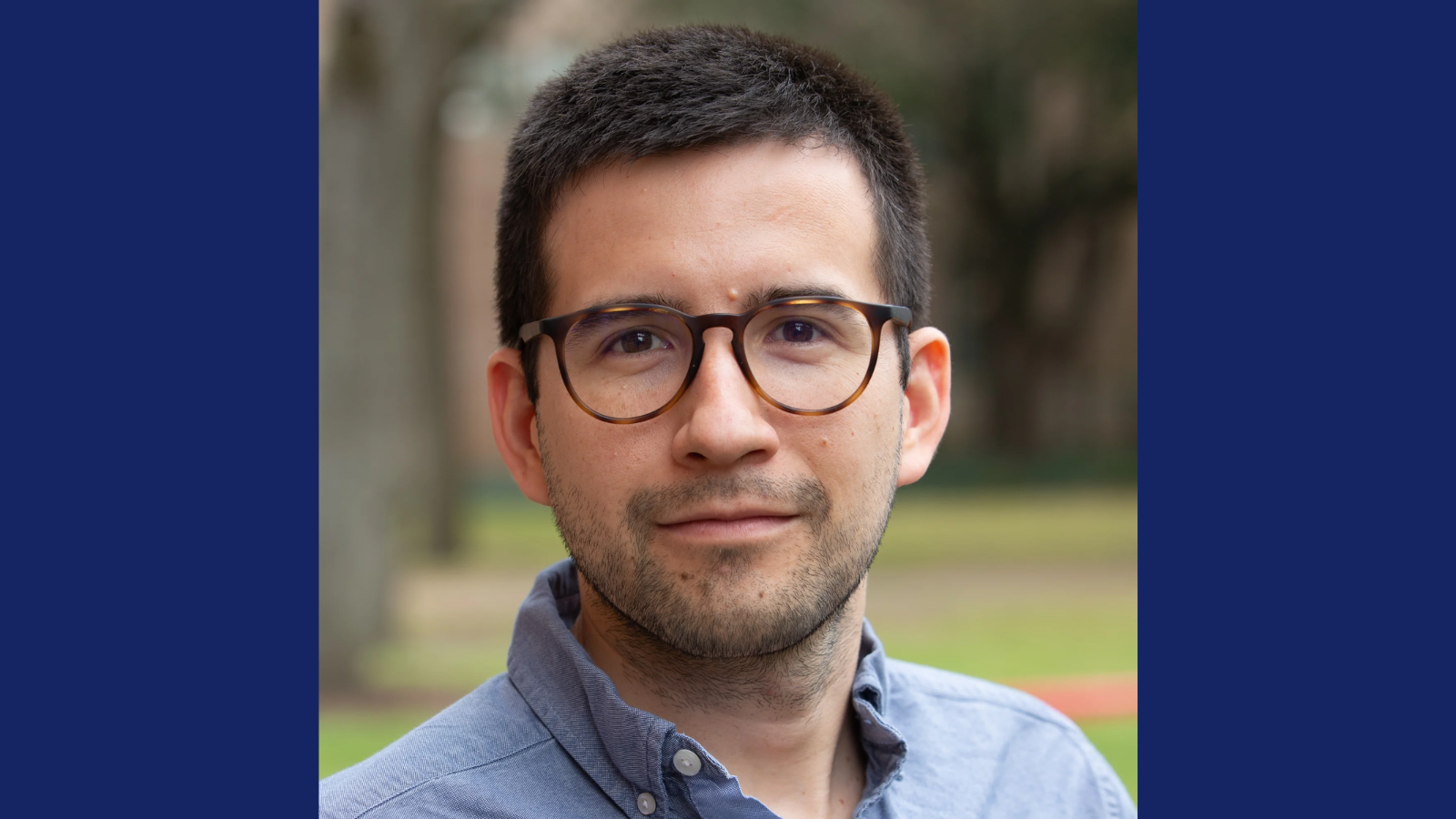 Professional headshot of Raul Rincon in a light blue button-down shirt and brown glasses.