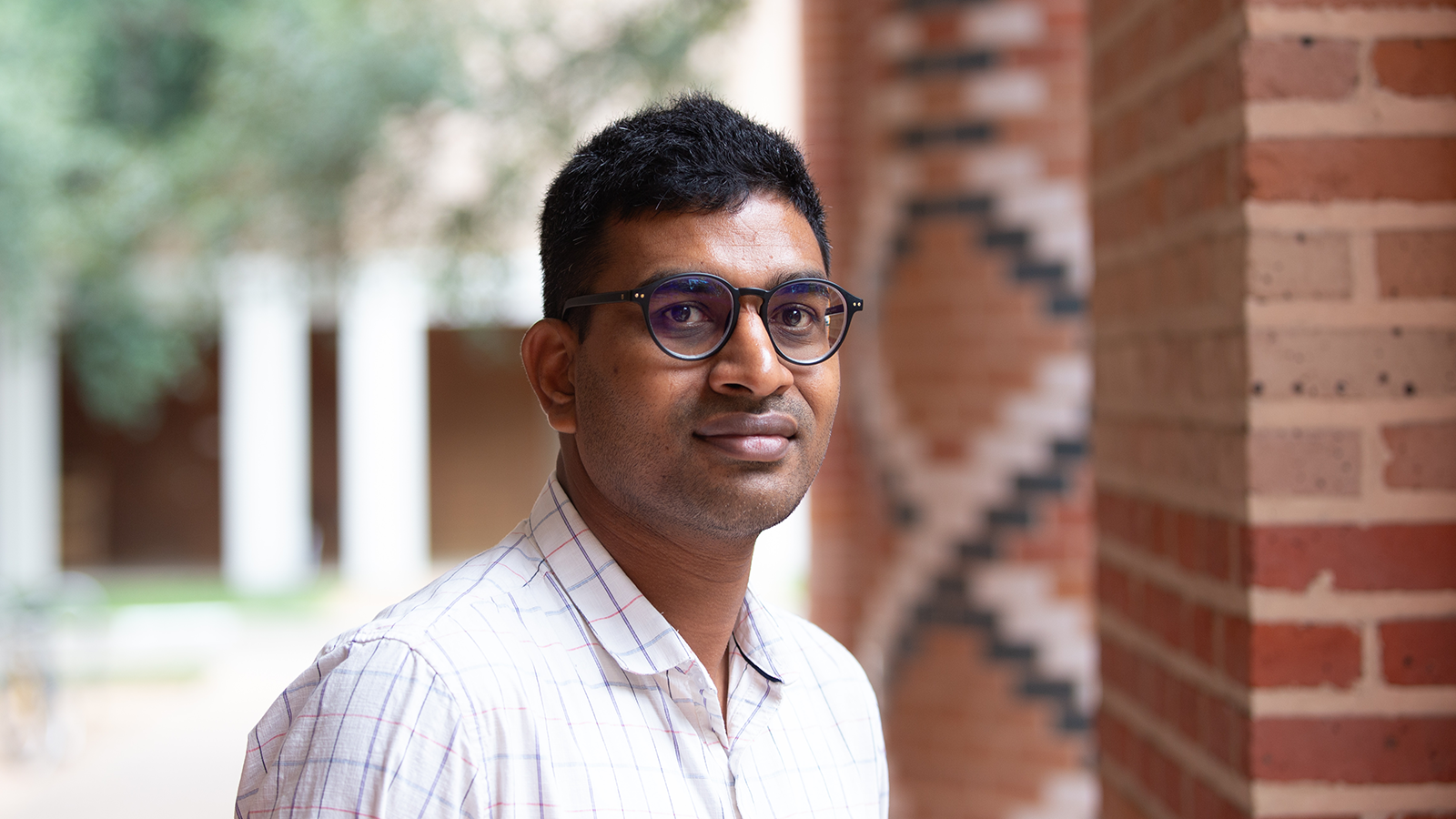 Professional headshot of Dr. Barun Mahata in a button-down shirt in front of a brick background on Rice University campus