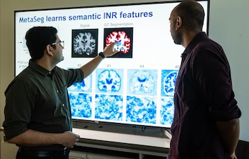 scientists pointing to pictures of the brain