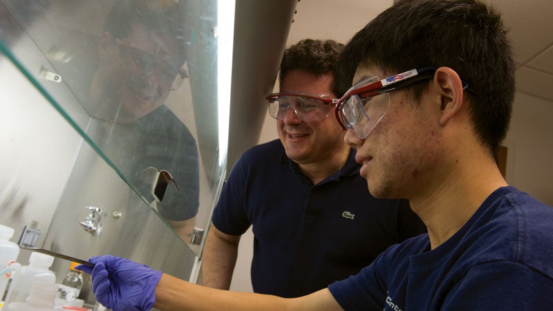 Student on right pointing at lab as Matteo Pasquali looks on