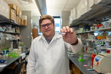 man in lab holding a device
