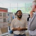 AI in Health conference attendees converse around a poster 