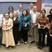Group of professionals, some holding awards pose together in front of a banner for the George R Brown School of Engineering and Computing.